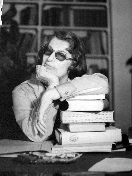 Silvina Ocampo en su escritorio recargada en un torre de libros